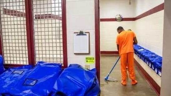 A detainee mops the floor at the intake station at the Stewart Detention Center in Lumpkin, Ga. (AP File Photo/Representative Image ) A detainee mops the floor at the intake station at the Stewart Detention Center in Lumpkin, Ga. (AP File Photo/Representative Image )