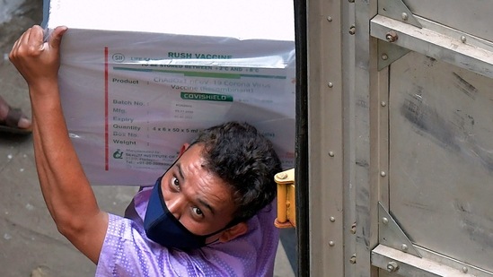 Workers transfer carton boxes of a Covishield vaccine developed by Pune based Serum Institute of India (SII) that arrived in a truck into the Karnataka Health Department cold storage facility in Bangalore. (AFP)