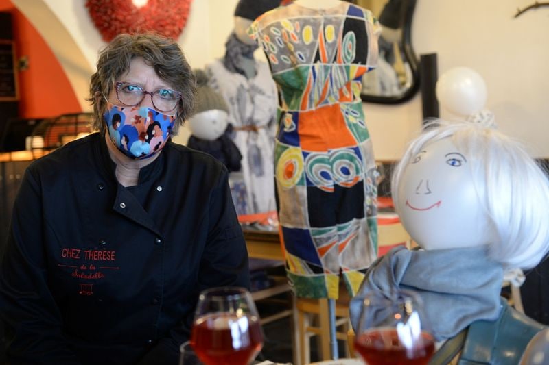 Thérèse, propriétaire du restaurant Chez Thérèse, pose à côté de mannequins à têtes de ballons.  (REUTERS)