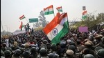 People shout anti-farmer slogans and wave India's national flags as police officers try to stop them, at a site of the protest against farm laws at Singhu border near New Delhi on January 29. (REUTERS) People shout anti-farmer slogans and wave India's national flags as police officers try to stop them, at a site of the protest against farm laws at Singhu border near New Delhi on January 29. (REUTERS)