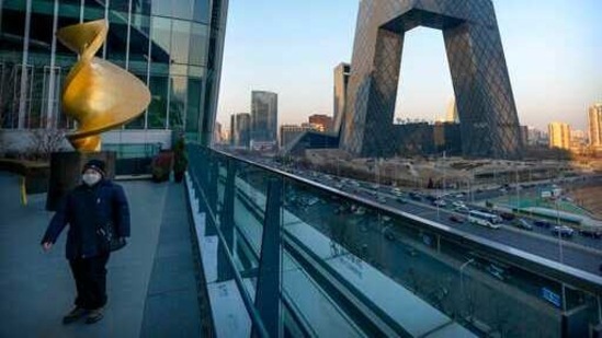 A man walks along an observation deck near Headquarters building of Chinese state-run television network CCTV and its overseas arm CGTN.(AP)