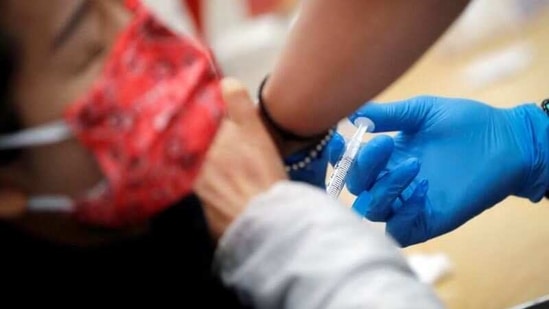 A healthcare worker administers a shot of the Moderna Covid-19 vaccine to a woman at a vaccination site in Manhattan.(Reuters File Photo)