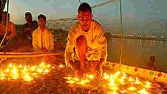 Hindu devotees light lamps, as they offer prayers on a boat, on the Ganges in Allahabad on Saturday, May 26, 2007.