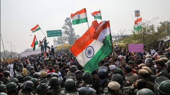 People shout anti-farmer slogans and wave India's national flags as police officers try to stop them, at a site of the protest against farm laws at Singhu border near New Delhi on January 29. (REUTERS)