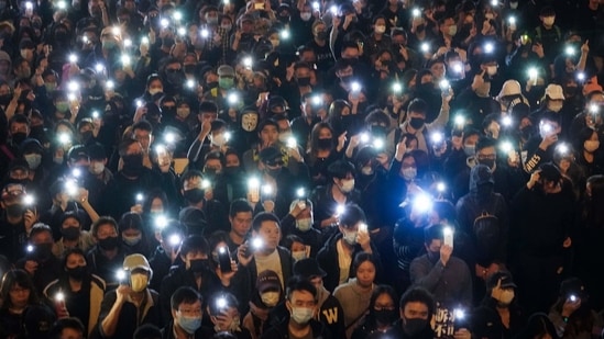 Pro-democracy protesters flash their smartphone lights as they gather on a street in Hong Kong on February 2, 2021. (AP) Pro-democracy protesters flash their smartphone lights as they gather on a street in Hong Kong on February 2, 2021. (AP)
