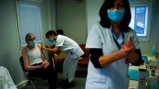 A nurse administrates a Pfizer/Biontech COVID-19 vaccine dose to a health care worker . (AP) A nurse administrates a Pfizer/Biontech COVID-19 vaccine dose to a health care worker . (AP)