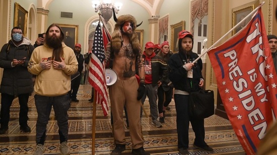 (FILES) In this file photo from on January 6, 2021, supporters of US President Donald Trump, including member of the QAnon conspiracy group Jake Angeli, aka Yellowstone Wolf (C), enter the US Capitol, in Washington, DC. - The American far right is angry: Angry at Joe Biden, angry at Donald Trump, angry at the enigmatic "Q" and angry with themselves.
The online postings and chatrooms of extremists have been brimming with disappointment and dissent since the failed January 6 insurrection against Congress and the inauguration of Joe Biden as president.
Followers of the QAnon conspiracy movement -- and its Delphic prophet Q -- are most in disarray, their millenarian predictions of chaos and doom accompanying Biden's elevation to the presidency not (or not yet) coming true.
Ultranationalists like the Proud Boys, armed militias such as the Oath Keepers, and dangerous white supremacists and neo-Nazis have been pushed further underground, with followers who took part in the Capitol attack being swept up by law enforcement. (Photo by Saul LOEB / AFP) (AFP) (FILES) In this file photo from on January 6, 2021, supporters of US President Donald Trump, including member of the QAnon conspiracy group Jake Angeli, aka Yellowstone Wolf (C), enter the US Capitol, in Washington, DC. - The American far right is angry: Angry at Joe Biden, angry at Donald Trump, angry at the enigmatic "Q" and angry with themselves.
The online postings and chatrooms of extremists have been brimming with disappointment and dissent since the failed January 6 insurrection against Congress and the inauguration of Joe Biden as president.
Followers of the QAnon conspiracy movement -- and its Delphic prophet Q -- are most in disarray, their millenarian predictions of chaos and doom accompanying Biden's elevation to the presidency not (or not yet) coming true.
Ultranationalists like the Proud Boys, armed militias such as the Oath Keepers, and dangerous white supremacists and neo-Nazis have been pushed further underground, with followers who took part in the Capitol attack being swept up by law enforcement. (Photo by Saul LOEB / AFP) (AFP)