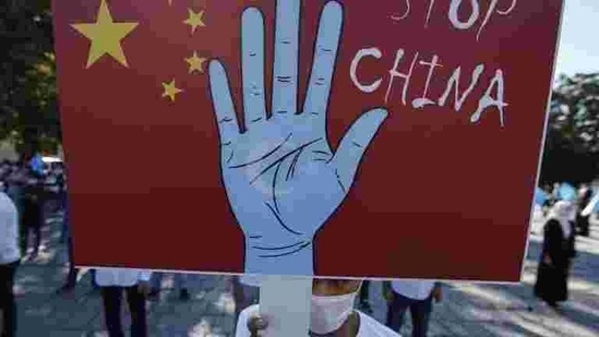 In this file photo taken on October 1, 2020, a protester from the Uighur community living in Turkey holds an anti-China placard in Istanbul, , against what they allege is oppression by the Chinese government to Muslim Uighurs in far-western Xinjiang province. (AP file)