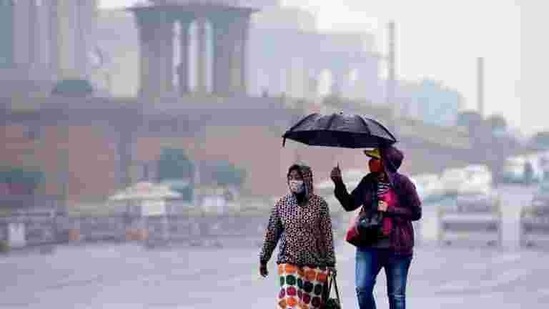 Commuters out in the rain at Vijay Chowk in New Delhi, India. (Arvind Yadav/HT PHOTO) Commuters out in the rain at Vijay Chowk in New Delhi, India. (Arvind Yadav/HT PHOTO)