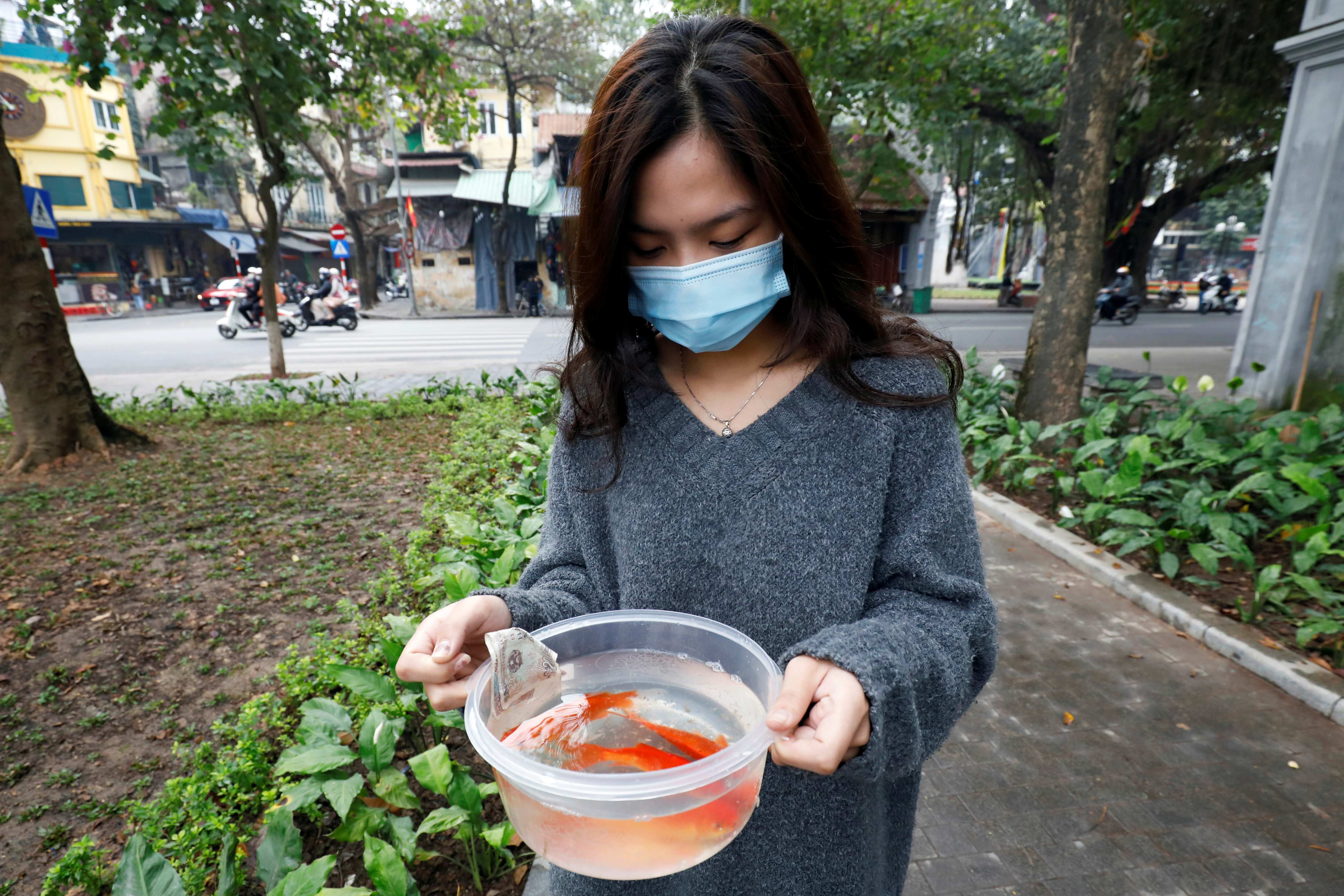 A woman prepares to release carps to Hoan Kiem lake on Kitchen God's Day as part of the traditional Vietnamese Lunar New Year celebrations, the biggest festival of the year in Hanoi, Vietnam. (REUTERS)