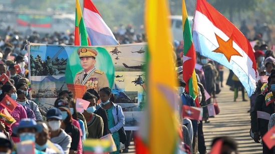Military supporters carry a portrait of junta leader General Min Aung Hlaing as they celebrate the coup in Naypyitaw, Myanmar. (REUTERS)