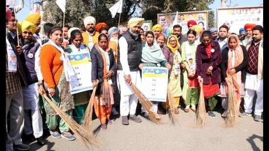 Punjab leader of opposition Harpal Singh Cheema (centre) and AAP members launching the civic body poll campaign by brooming streets in Bathinda on Friday. The Aam Aadmi Party’s poll symbol is the broom. (Sanjeev Kumar/HT)