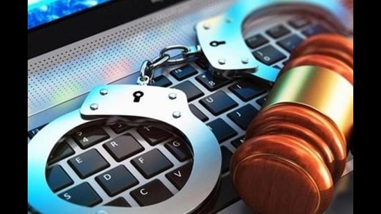 Creative abstract cyber crime, online piracy and internet web hacking concept: 3D render illustration of the macro view of metal handcuffs and wooden judge mallet, gavel or hammer on laptop notebook computer keyboard with selective focus effect (Getty Images/iStockphoto)