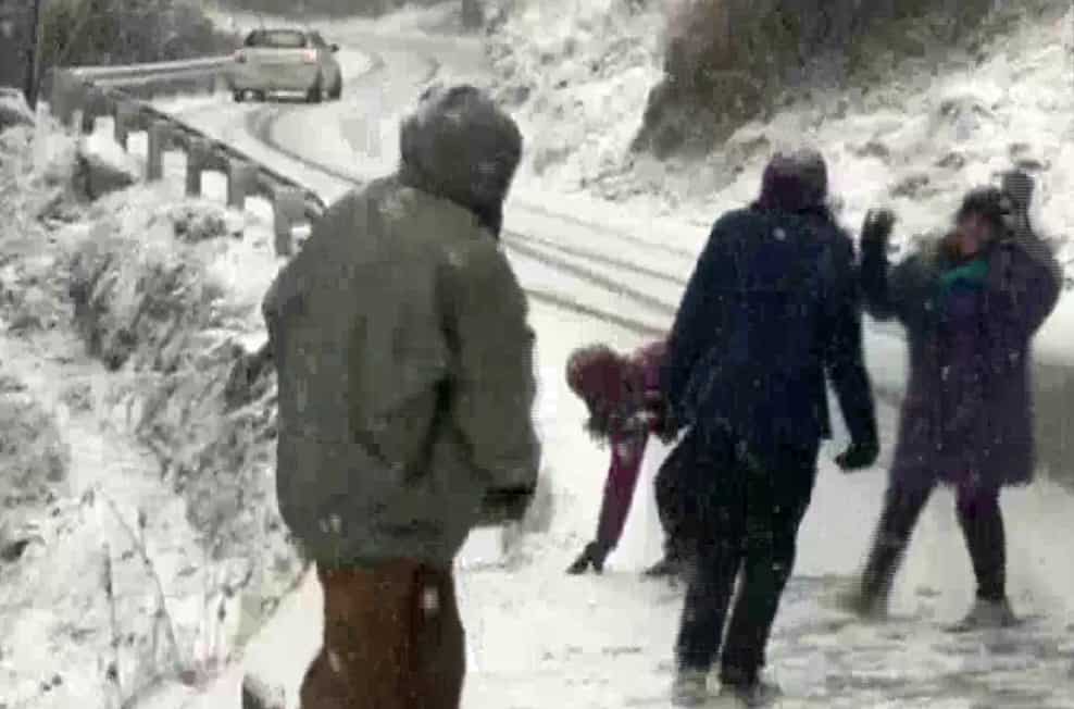 Tourists enjoy snowfall