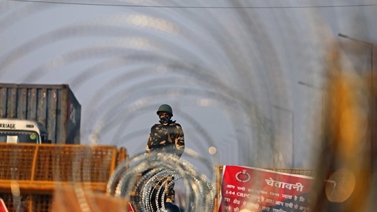 A police officer in riot gear stands guard beyond razor wire coils along a highway in Ghazipur on the outskirts of New Delhi, India, on Saturday, Feb. 6, 2021. Farmers, who have been camped on the outskirts of the Indian capital since late November, have called for roads to be blocked across India to demand repeal of the new legislation pushed through parliament by Prime Minister Narendra Modi government, which they say will allow corporates to take control of farming. Photographer: Anindito Mukherjee/Bloomberg (Bloomberg) A police officer in riot gear stands guard beyond razor wire coils along a highway in Ghazipur on the outskirts of New Delhi, India, on Saturday, Feb. 6, 2021. Farmers, who have been camped on the outskirts of the Indian capital since late November, have called for roads to be blocked across India to demand repeal of the new legislation pushed through parliament by Prime Minister Narendra Modi government, which they say will allow corporates to take control of farming. Photographer: Anindito Mukherjee/Bloomberg (Bloomberg)