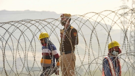 Workers at a site to make barricades, to stop farmers from marching towards the national capital during their ongoing protest against Centre's farm reform laws, at Ghazipur border in New Delhi. (PTI) Workers at a site to make barricades, to stop farmers from marching towards the national capital during their ongoing protest against Centre's farm reform laws, at Ghazipur border in New Delhi. (PTI)