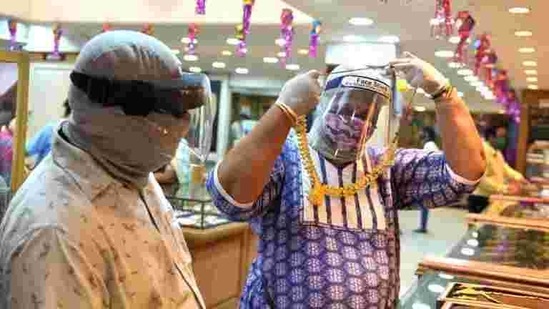 Citizens take precautions as they buy gold on the occasion of Dhanteras on Friday. (Satish Bate/HT Photo) Citizens take precautions as they buy gold on the occasion of Dhanteras on Friday. (Satish Bate/HT Photo)