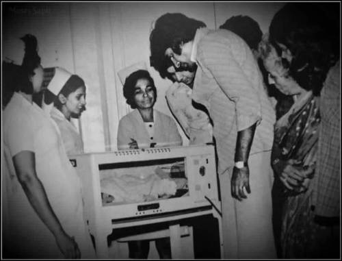 Amitabh Bachchan looking at a newborn Abhishek. Amitabh Bachchan looking at a newborn Abhishek.