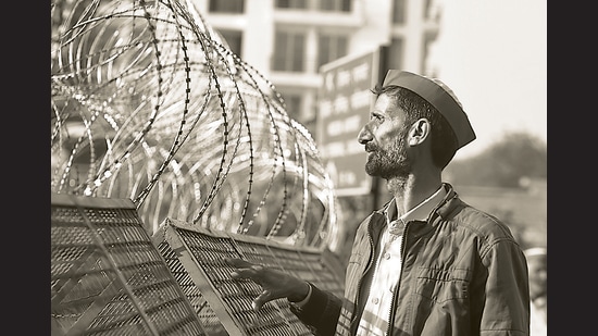 Ghaziabad, India - February 05: A farmer looks through barbed wires over barricades placed by Delhi Police at Ghazipur (Delhi-UP border) during the ongoing protest against the new farm laws, near Ghaziabad, India, on Friday, February 5, 2021. (Photo by Sanchit Khanna /Hindustan Times) (Sanchit Khanna/HT PHOTO) Ghaziabad, India - February 05: A farmer looks through barbed wires over barricades placed by Delhi Police at Ghazipur (Delhi-UP border) during the ongoing protest against the new farm laws, near Ghaziabad, India, on Friday, February 5, 2021. (Photo by Sanchit Khanna /Hindustan Times) (Sanchit Khanna/HT PHOTO)