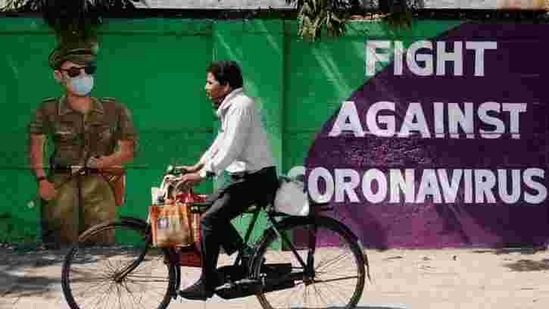 A man cycles past a graffiti-covered wall amidst the spread of the coronavirus disease on a street in Navi Mumbai in this file photo.(Reuters)