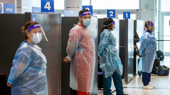 Healthcare workers prepare to test passengers as they arrive at Toronto's Pearson airport. (REUTERS)