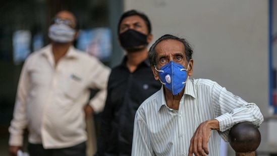 People wearing protective masks look up at the Bombay Stock Exchange (BSE) building in Mumbai, India, on Thursday, Jan. 21, 2021. (Bloomberg)