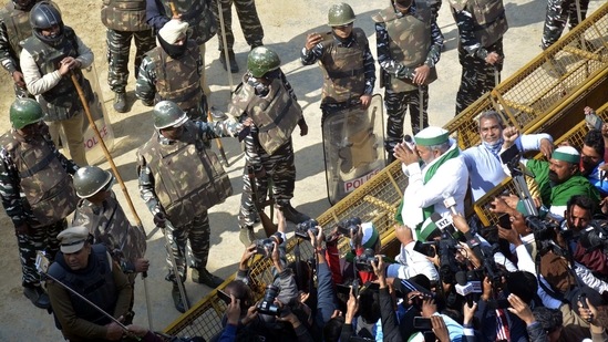 Bharatiya Kisan Union (BKU) leader Rakesh Tikait gestures towarsds police personnel deployed during the “Chakka Jam” strike, at Ghazipur in New Delhi on February 6. At the three border points – Singhu, Tikri and Ghazipur – the protests remained peaceful after farm leaders repeatedly told the protesters not to cross the barricades to enter Delhi. The Delhi Police have placed multiple layers of barricades at the borders to ensure that the protesters do not drive their tractors into the national capital.(Sakib Ali / HT Photo)