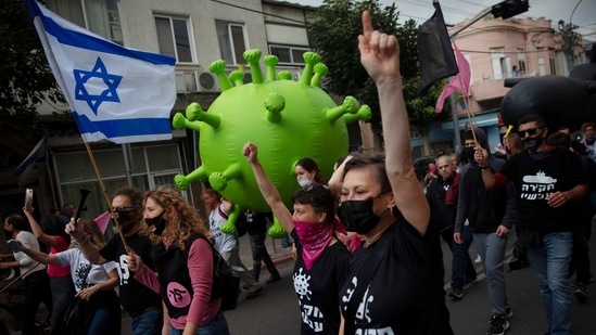 Israeli protesters march with a large inflatable model of the coronavirus during a demonstration against Israeli PM Benjamin Netanyahu.(AP)