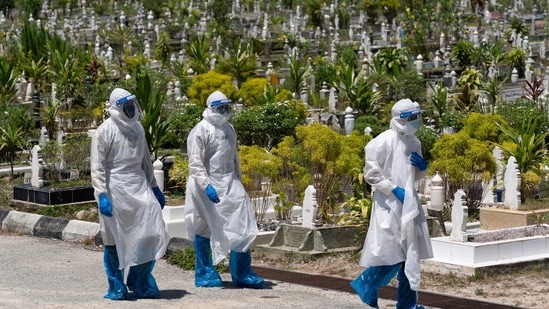 Workers wearing personal protective equipment (PPE) leave after burying a victim of the coronavirus disease at a Muslim cemetery in Gombak, outskirts of Kuala Lumpur, Malaysia.(AP) Workers wearing personal protective equipment (PPE) leave after burying a victim of the coronavirus disease at a Muslim cemetery in Gombak, outskirts of Kuala Lumpur, Malaysia.(AP)