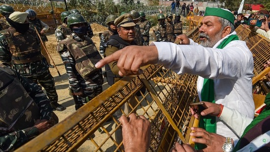 New Delhi: BKU leader Rakesh Tikait gestures towards security personnel who had blocked farmers' movement during their protest against Centre's farm laws, at Ghazipur border in New Delhi on Saturday. (PTI Photo ) New Delhi: BKU leader Rakesh Tikait gestures towards security personnel who had blocked farmers' movement during their protest against Centre's farm laws, at Ghazipur border in New Delhi on Saturday. (PTI Photo )