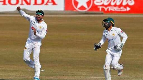 Pakistan's Babar Azam, left, and Mohammad Rizwan celebrate after winning the match against South Africa on the end of the second cricket test match between Pakistan and South Africa at the Pindi Stadium in Rawalpindi. (AP)