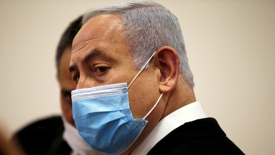 FILE PHOTO: Israeli Prime Minister Benjamin Netanyahu, wearing a face mask, looks on while standing inside the court room as his corruption trial opens at the Jerusalem District Court May 24, 2020. REUTERS/Ronen Zvulun/File Photo(REUTERS)