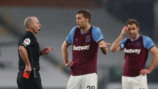 Soucek is shown a red card by referee Mike Dean. (Pool via REUTERS)