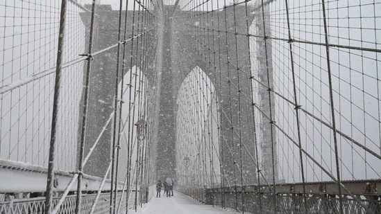 People walking on the Brooklyn Bridge during a snowstorm on February 7. This is the second largest snowstorm to hit the New York area in less than a week.(Kathy Willens / AP)