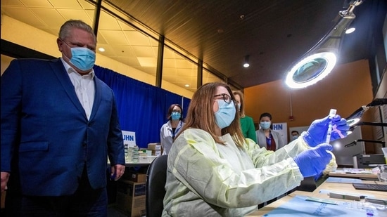 Ontario Premier Doug Ford watches a healthcare worker prepare a Pfizer-BioNTech coronavirus disease vaccine at The Michener Institute, in Toronto, Canada on January 4. (Reuters file)