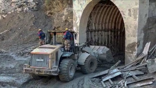 ITBP personnel use machinery to clear muck as they try to enter a tunnel to rescue trapped workers of a power plant, in Tapovan area of Uttarakhand on Monday.(AP Photo)