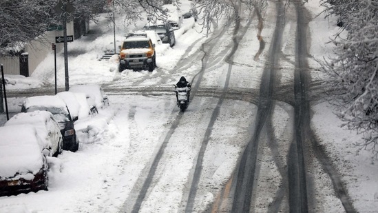 A person rides a scooter during a snow storm February 07, 2021 in New York City. The region around New York is experiencing its second major snow storm in a week with up to 8 inches expected in the city and outlying areas.(Spencer Platt / Getty Images / AFP)