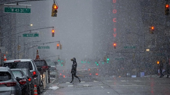 A woman crosses 6th Avenue as snow falls in New York City on February 7. People in the northern United States face the risk of frostbite and hypothermia amid bitter cold temperatures and dangerous wind chills this weekend.(Kena Betancur / AFP)