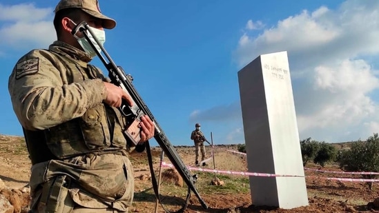 Turkish police officers guard a monolith, found on an open field near Sanliurfa, southeastern Turkey, Sunday, Feb. 7, 2021. The metal block was found by a farmer Friday in Sanliurfa province with old Turkic script that reads "Look at the sky, see the moon." The monolith, 3 meters high (about 10 feet), was discovered near UNESCO World Heritage site Gobeklitepe with its megalithic structures dating back to 10th millennium B.C. Turkish media reported Sunday that gendarmes were looking through CCTV footage and investigating vehicles that may have transported the monolith. Other mysterious monoliths have popped up and some have disappeared in numerous countries since 2020. (AP)