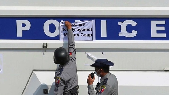 Police remove a sticker from a police vehicle during a protest against the military coup, in Naypyitaw on February 8. The unrest has revived memories of almost half a century of direct army rule until the military began a process of withdrawing from civilian politics in 2011, though it never gave up its overall control over the Suu Kyi's civilian government after it won a 2015 election.(REUTERS)
