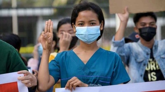 A nurse shows the three-finger salute as she takes part in a protest against the military coup and to demand the release of elected leader Aung San Suu Kyi, in Yangon, on February 8. Activists are also seeking the abolition of a 2008 constitution drawn up under military supervision that gave the generals a veto in parliament and control of several ministries, and for a federal system in ethnically diverse Myanmar.(REUTERS)