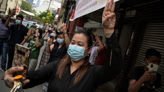A supporter of Myanmar's National League for Democracy (NLD) gives a three-fingered salute during the read out by NLD members in Malaysia of a statement against the recent military coup, on a street in Kuala Lumpur. (AP) A supporter of Myanmar's National League for Democracy (NLD) gives a three-fingered salute during the read out by NLD members in Malaysia of a statement against the recent military coup, on a street in Kuala Lumpur. (AP)