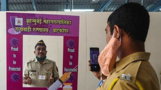 A policeman gets himself photographed after getting vaccinated at a selfie point erected to create awareness on Covid-19 vaccination at a government hospital in Mumbai. (AP) A policeman gets himself photographed after getting vaccinated at a selfie point erected to create awareness on Covid-19 vaccination at a government hospital in Mumbai. (AP)