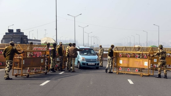 Police personnel block the road going to Uttar Pradesh through Delhi Meerut expressway with barricades during the ongoing protest against the new farm laws at Ghazipur border in New Delhi on Friday. (ANI Photo) Police personnel block the road going to Uttar Pradesh through Delhi Meerut expressway with barricades during the ongoing protest against the new farm laws at Ghazipur border in New Delhi on Friday. (ANI Photo)