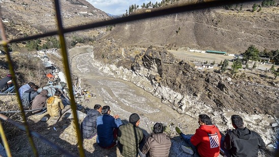 Villagers watch rescue operations being carried out at Tapovan tunnel on February 10. Machines were pressed to remove more slush from the tunnel through the night. The tunnel is still approachable till about 120 meters, ANI reported. However, more slush and water coming from inside the tunnel is making the way ahead difficult.(Arun Sharma / PTI)