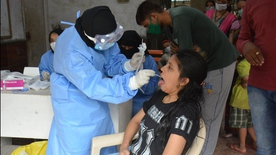 A healthcare worker collects a swab sample of a woman to test for Covid-19 infection, in Bhiwandi. (HT FILE) A healthcare worker collects a swab sample of a woman to test for Covid-19 infection, in Bhiwandi. (HT FILE)