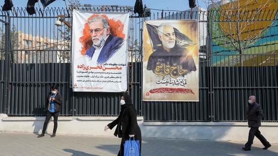 Iranians walk past a poster depicting late Revolutionary Guards commander Qasem Soleimani (R) and nuclear scientist Mohsen Fakhrizadeh, assassinated last month, in the capital Tehran.(AFP) Iranians walk past a poster depicting late Revolutionary Guards commander Qasem Soleimani (R) and nuclear scientist Mohsen Fakhrizadeh, assassinated last month, in the capital Tehran.(AFP)