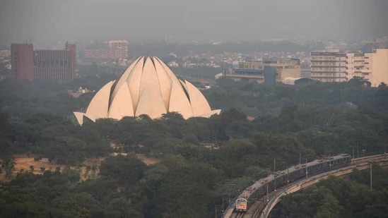 A metro train passes Lotus Temple in the afternoon at Kalkaji in New Delhi. A metro train passes Lotus Temple in the afternoon at Kalkaji in New Delhi.