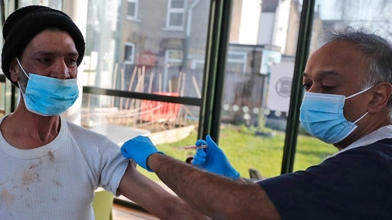 Doctor Anil Mehta administers a dose of the AstraZeneca vaccine to a homeless person at the Welcome Centre in Ilford, east London. (AP) Doctor Anil Mehta administers a dose of the AstraZeneca vaccine to a homeless person at the Welcome Centre in Ilford, east London. (AP)