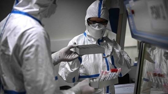 Laboratory technicians wearing protective equipment work on the genome sequencing of the SARS-CoV-2 virus (Covid-19) and its variants. (AFP) Laboratory technicians wearing protective equipment work on the genome sequencing of the SARS-CoV-2 virus (Covid-19) and its variants. (AFP)